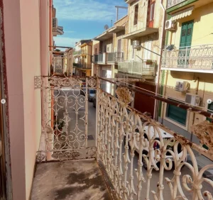 Balcon en fer forgé typique donnant sur une rue sicilienne, appartement proposé à la vente par CET Invest.