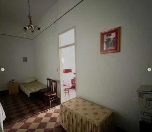 Chambre secondaire d’un appartement en Sicile avec lit simple et décoration traditionnelle.