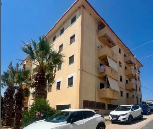 Immeuble résidentiel en Sicile avec balcons et volets, bien immobilier présenté par CET Invest.